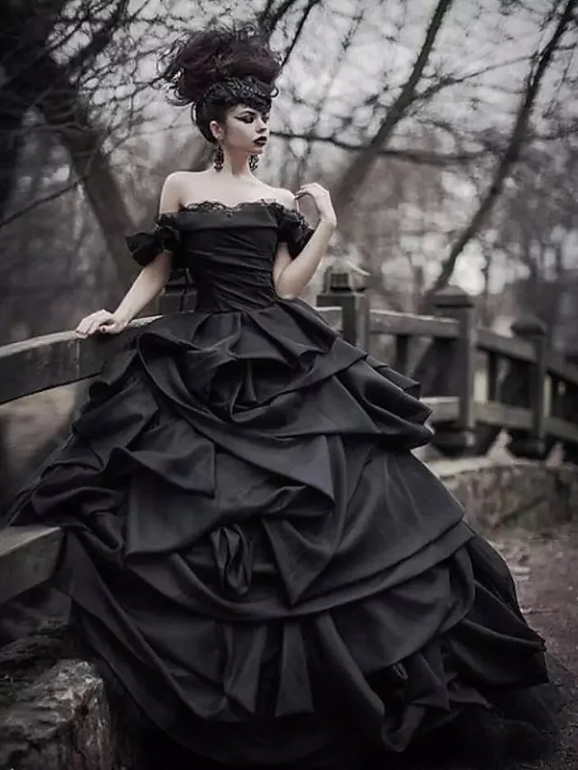 Side view of a black off-shoulder ball gown wedding dress, showcasing the court train.