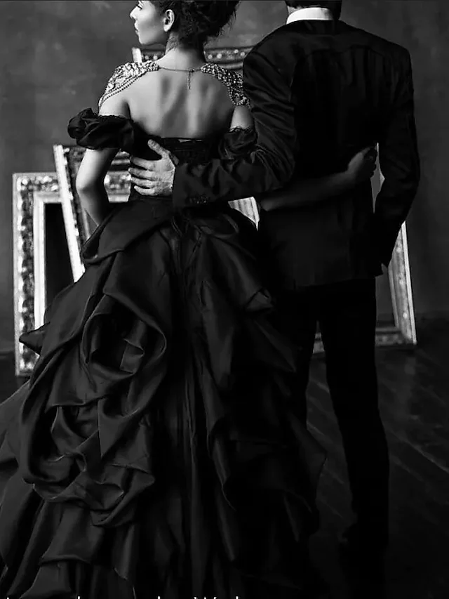 Close-up of the off-shoulder lace bodice on a black wedding ball gown.