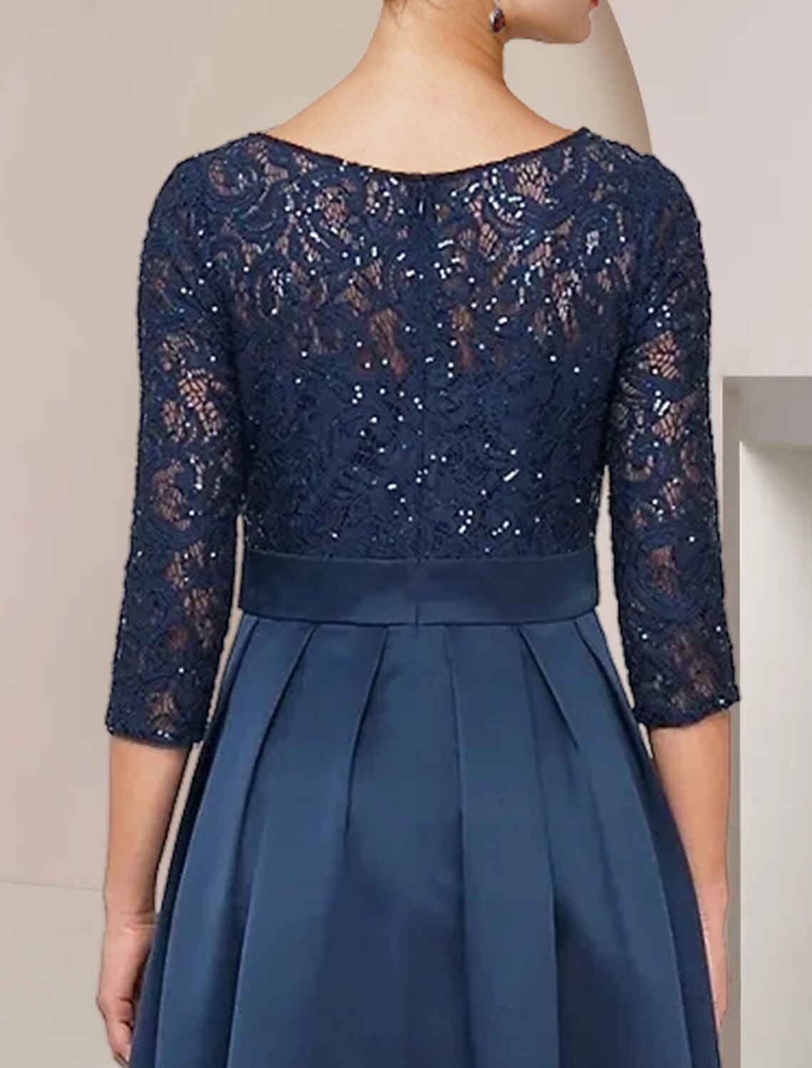 Close-up of the scoop neck and 3/4 length lace sleeves on the dress.