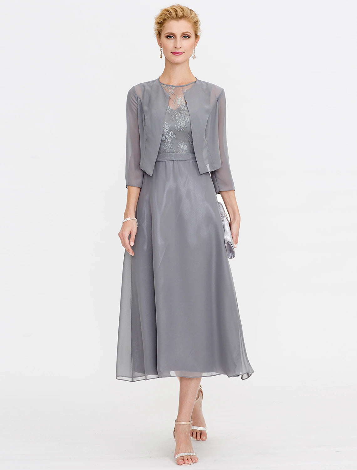 Woman in elegant A-line tea length mother of the bride dress with illusion neck and lace details.