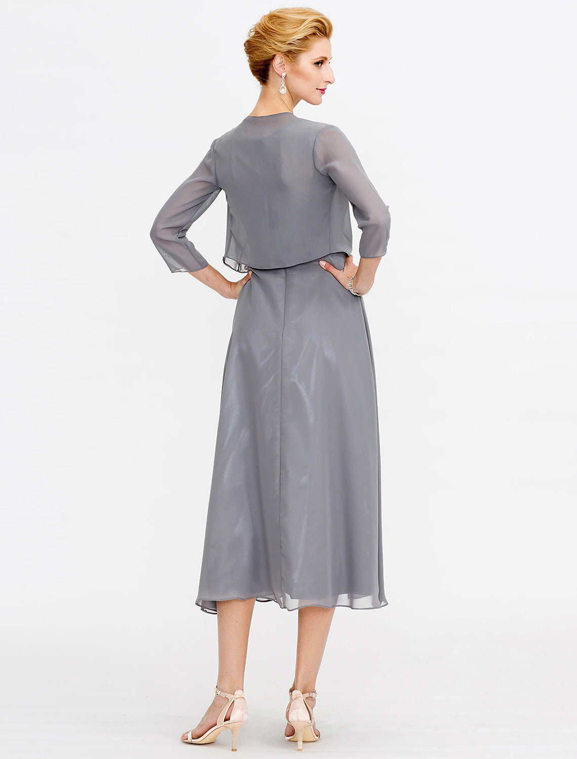 Woman posing in a fall wedding guest dress, highlighting the flowy tea length skirt.