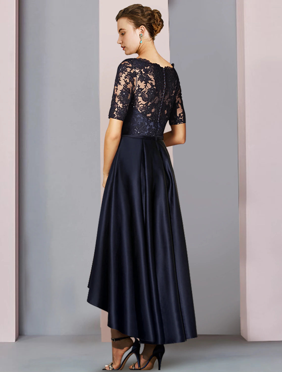 Back view of an elegant A-line Mother of the Bride dress, showcasing the high-low hem and pleats.