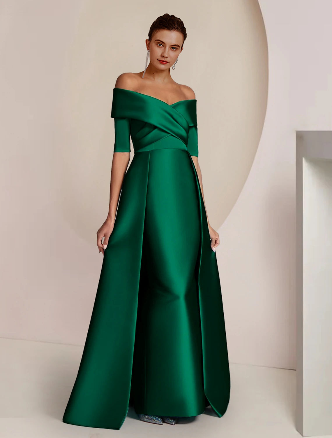Woman wearing an elegant off-shoulder satin sheath dress with half sleeves, standing gracefully.