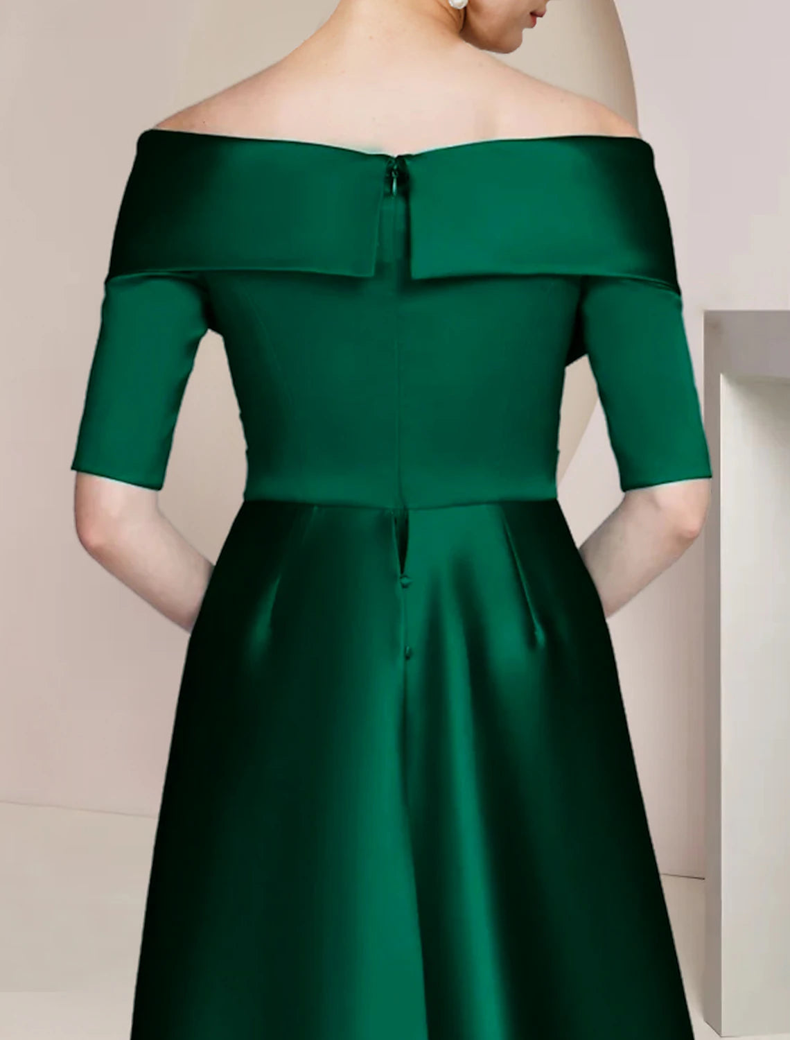 Close-up of the off-shoulder neckline and half sleeves of a satin formal gown.