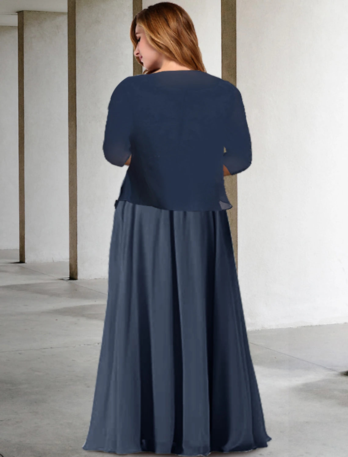 Back view of a plus-size formal chiffon gown with delicate pleats.