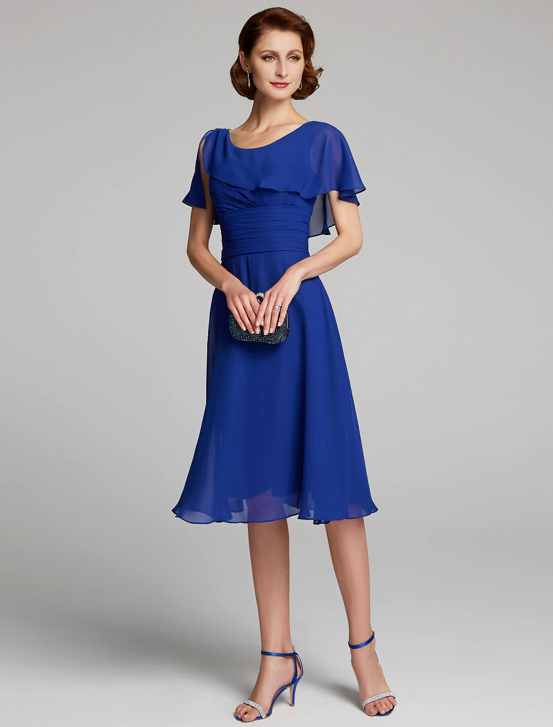 Woman wearing a LUOLANDI A-line chiffon mother of the bride dress with cowl neck and short sleeves.