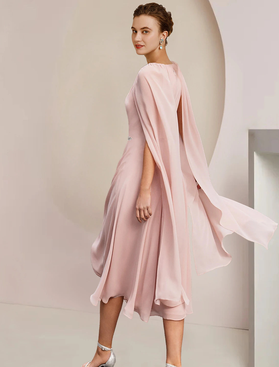 Back view of sleeveless A-line chiffon dress with crystal brooch.