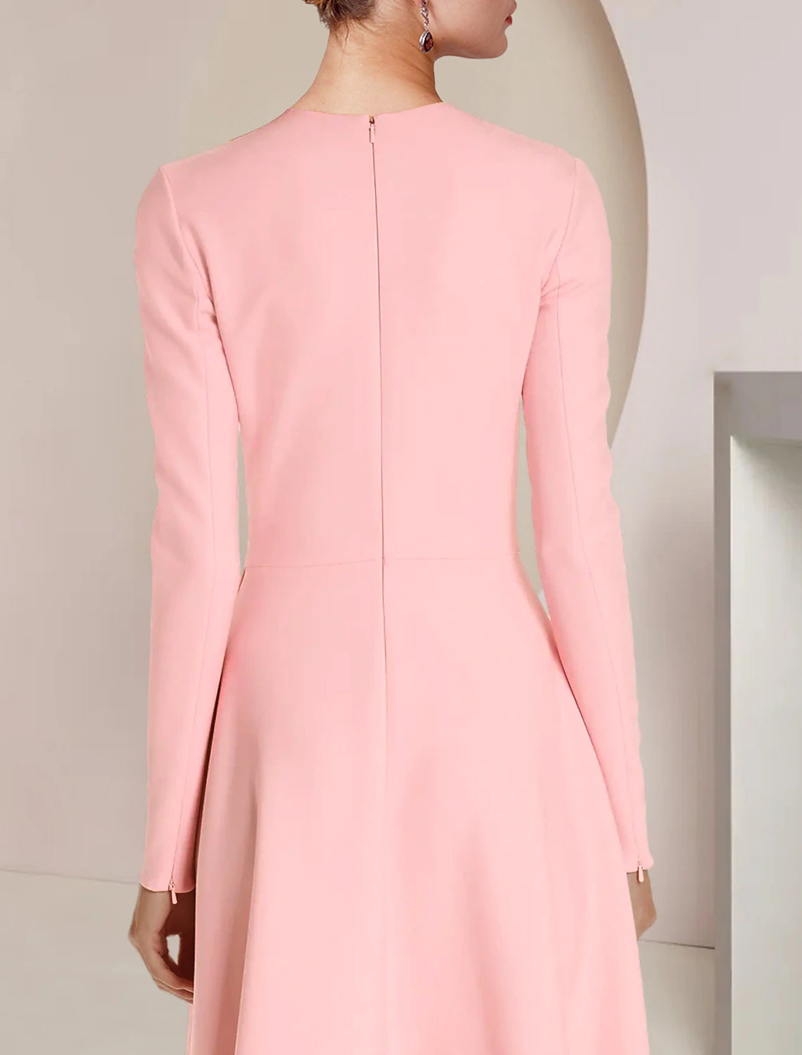 Close-up of the scoop neckline and ruffled long sleeves on the elegant dress.