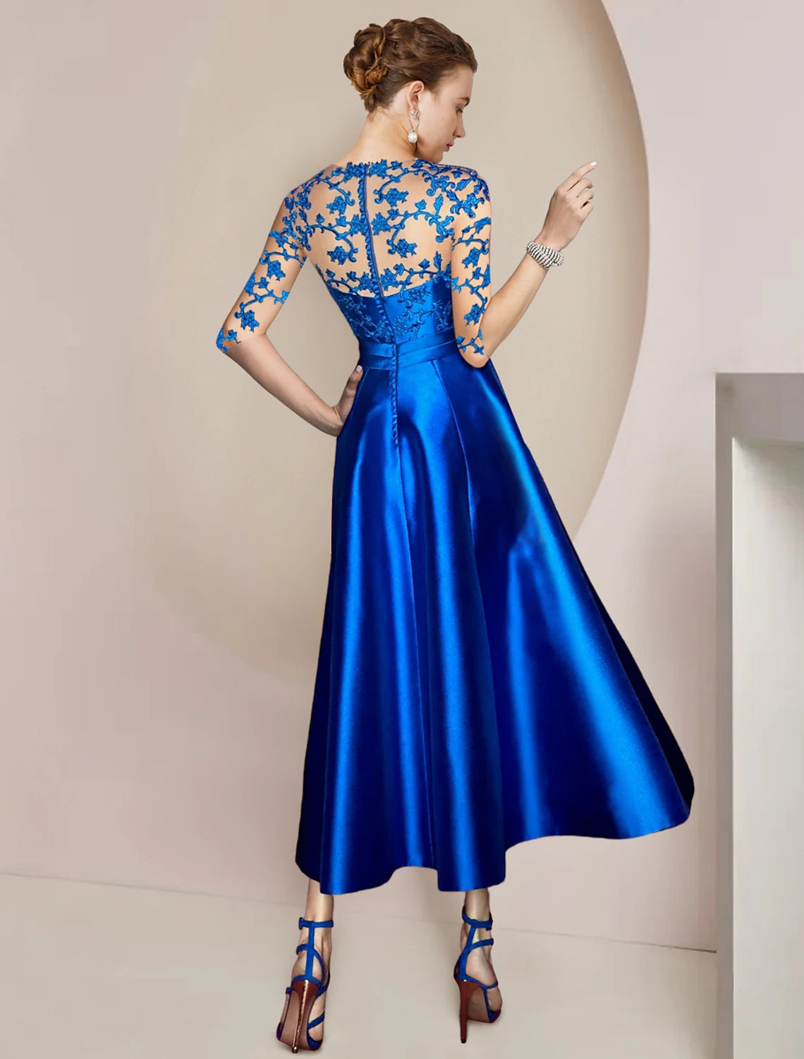 A-line tea-length gown with pleats and bow details, side view.