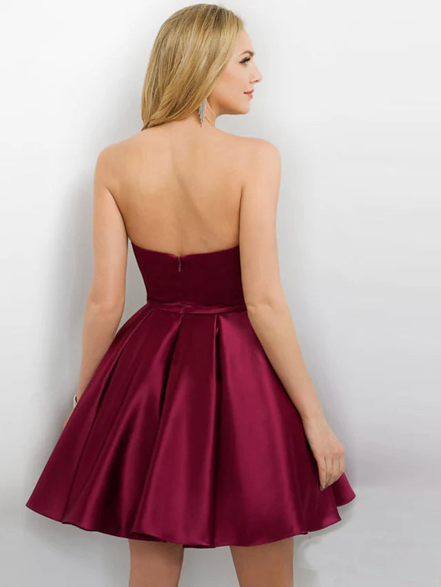Woman posing in a strapless short satin party dress.
