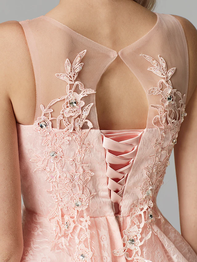 Close-up of the pink tulle, floral lace, and sequin details on the dress.