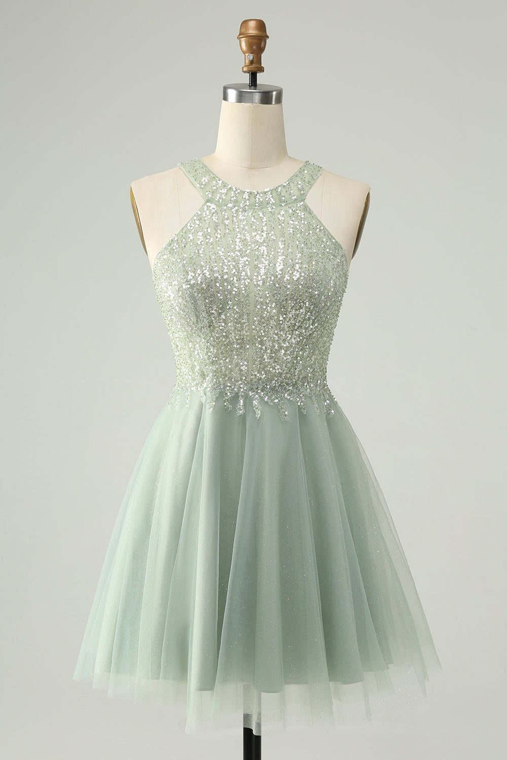 Model wearing a dusty green A-line halter short homecoming dress with sequins, posing frontally.