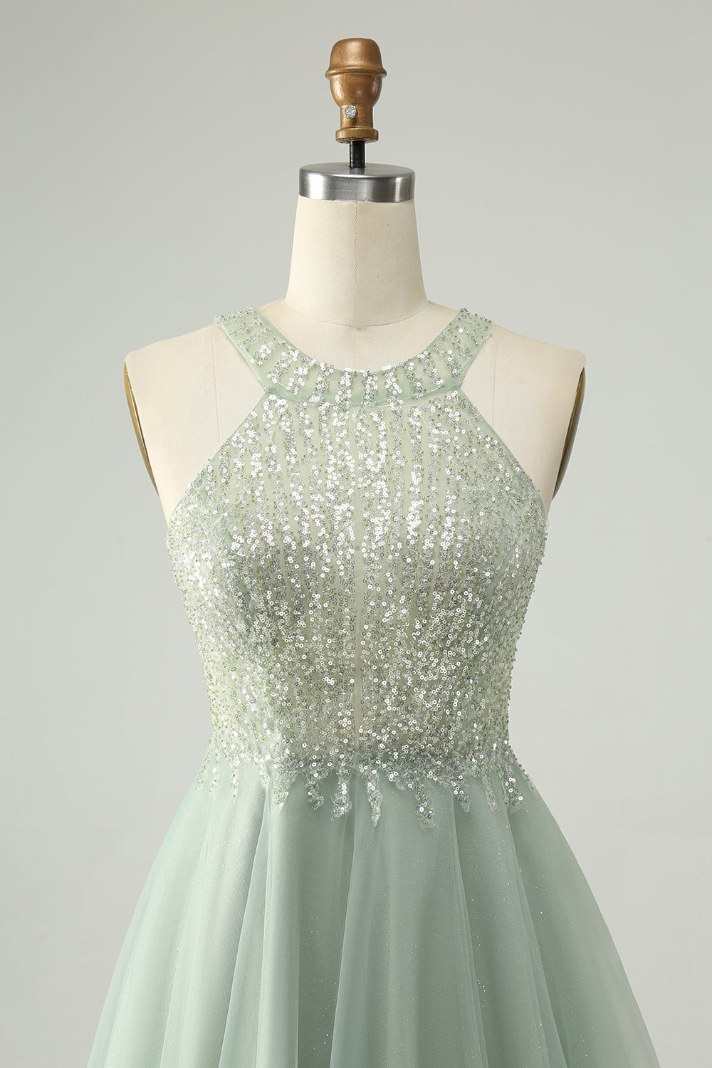 Close-up of the sequin embellishments on the dusty green halter homecoming dress fabric.