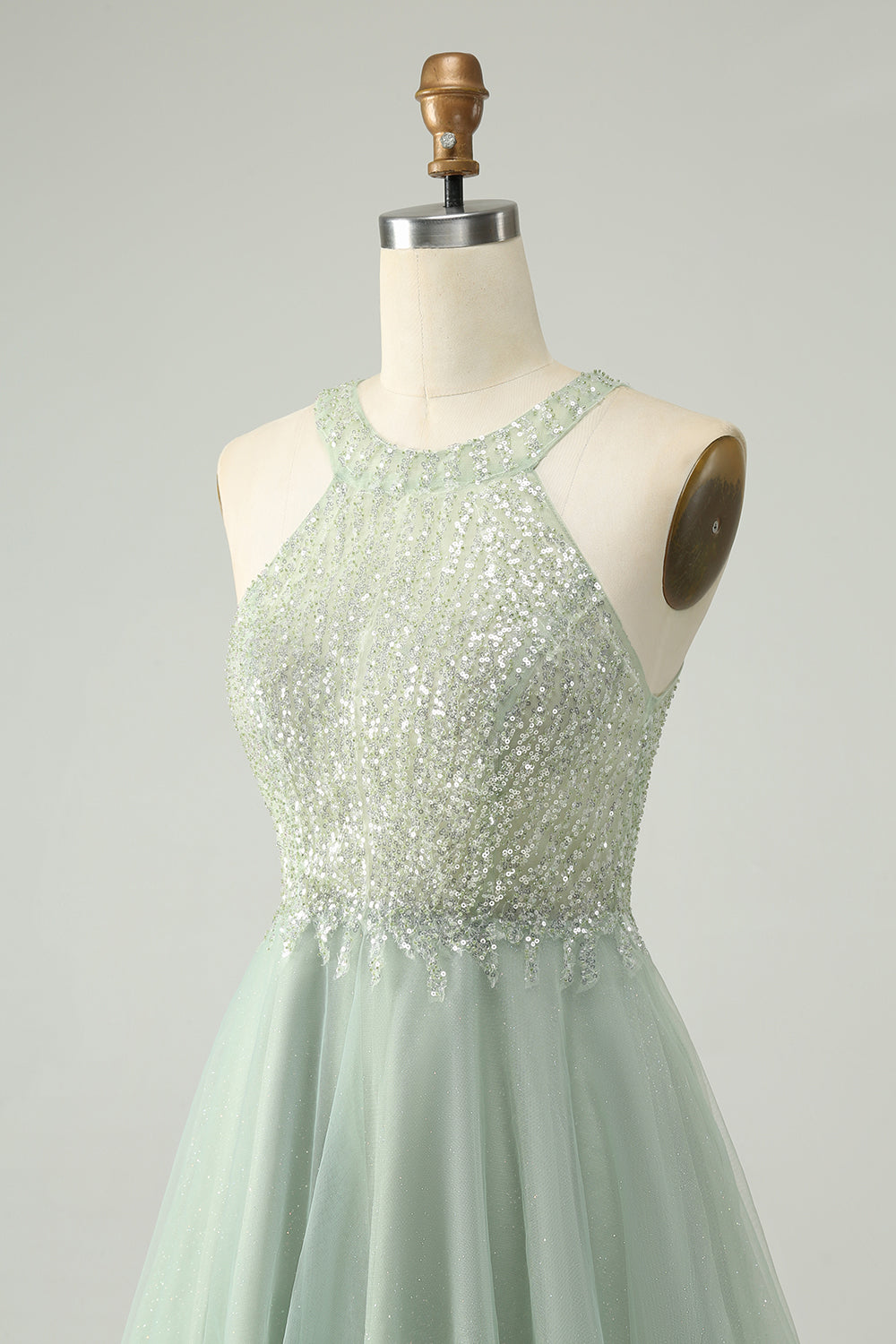 Model posing in the dusty green A-line halter short homecoming dress, showing movement.