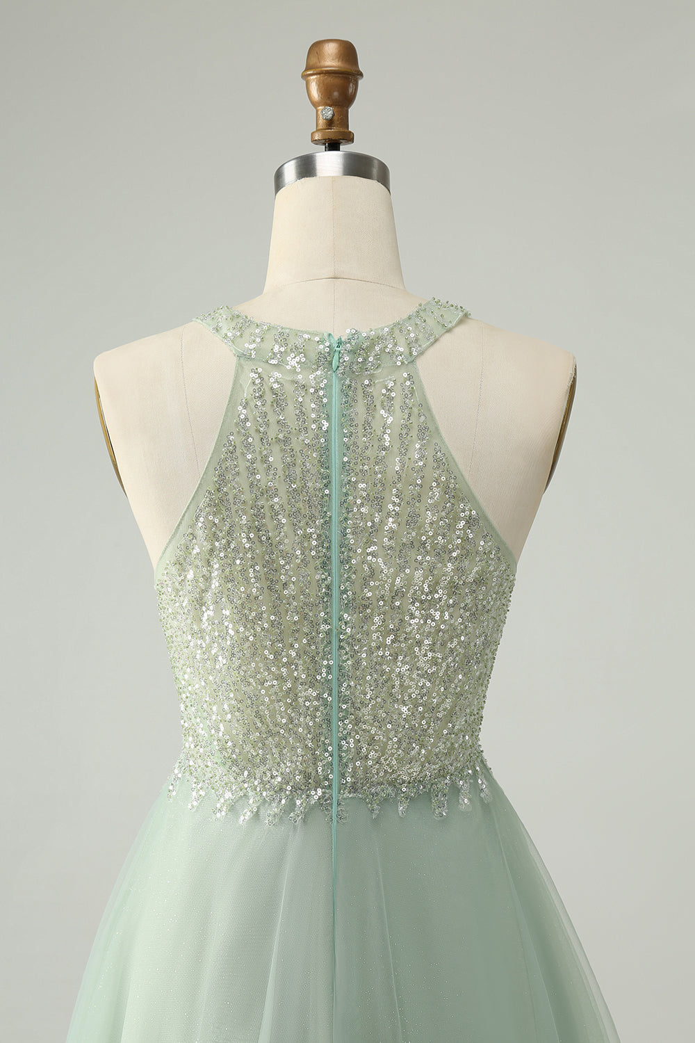 Detailed view of the halter neckline and sequined bodice of the dusty green dress.