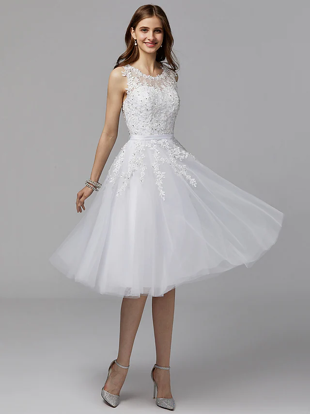 Woman wearing an elegant A-line floral lace tea-length dress with an illusion neck and beading.