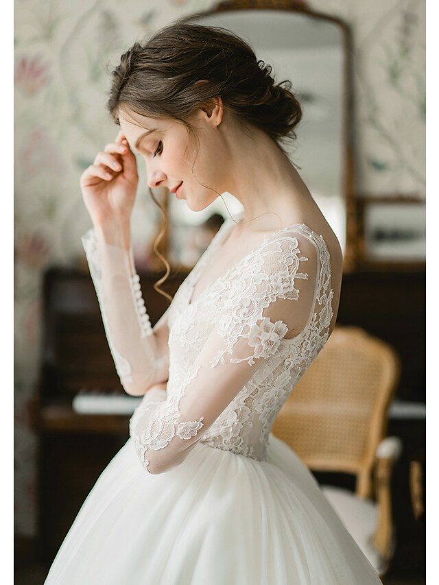 Bride posing gracefully in a formal V-neck wedding dress with pleats.