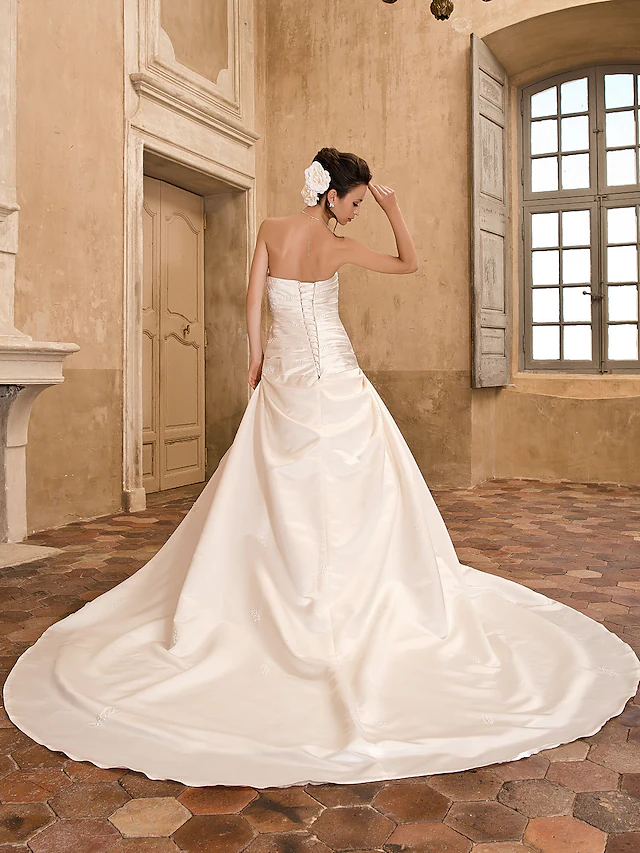 Close-up of the strapless neckline and satin fabric of the Luolandi wedding dress.
