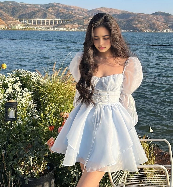 Model wearing a sweet A-line short dress with long sleeves.
