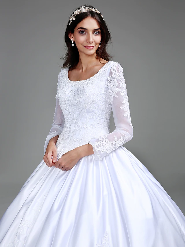Detailed view of the satin fabric and delicate appliques on the wedding gown.